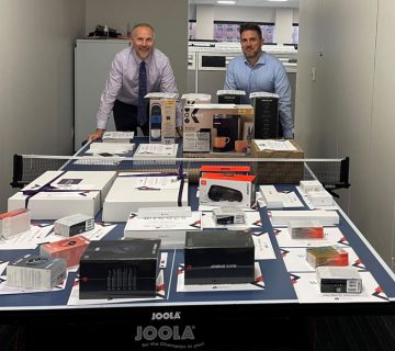 Picture of two IIS staff over a table of large gifts for the Christmas Giveaway event